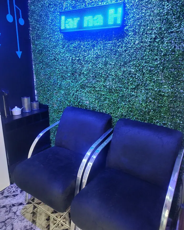 Sala de espera da ByteCell, com poltronas azuis e parede verde